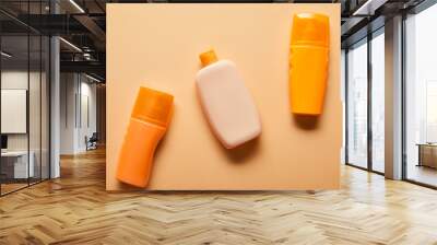 top view of sunscreen products in bottles on beige background Wall mural