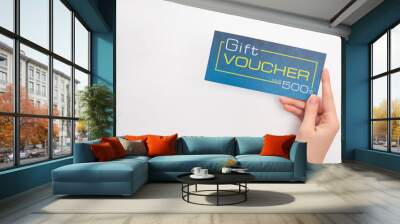 Top view of woman holding blue gift voucher with value and dollar sign on white background Wall mural