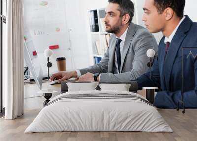 two focused businessmen in formal wear working with desktop computer in office Wall mural