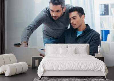 two focused businessmen working with papers and laptop in office Wall mural