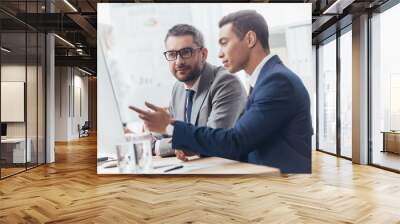 two professional businessmen discussing and using desktop computer in office Wall mural