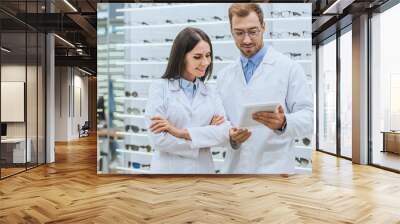 two professional oculists working and using digital tablet in optica Wall mural