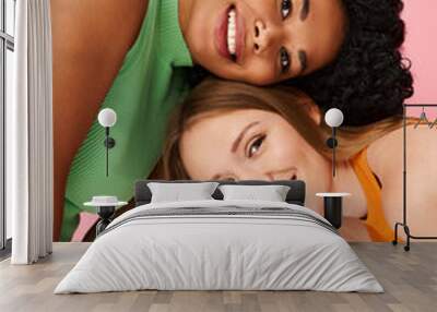 Two young women in casual attire posing for a picture. Wall mural