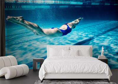 underwater picture of young female swimmer exercising in swimming pool Wall mural