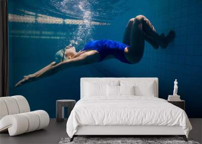 underwater picture of young female swimmer exercising in swimming pool Wall mural