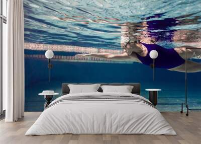 underwater picture of young female swimmer exercising in swimming pool Wall mural