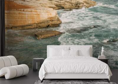 white foam near rocks in blue sea Wall mural