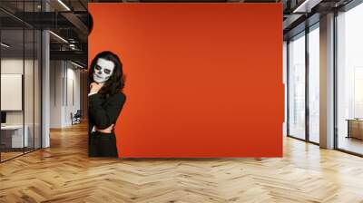 woman in sugar skull makeup and white suit with black balloons near spooky man on red, banner Wall mural