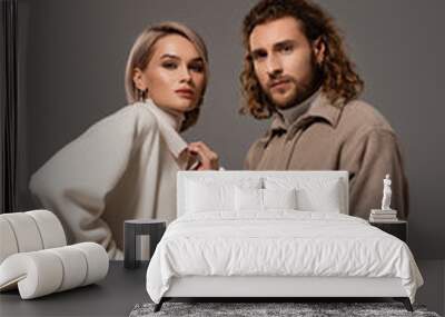 woman in white coat and man in shirt looking at camera isolated on grey Wall mural