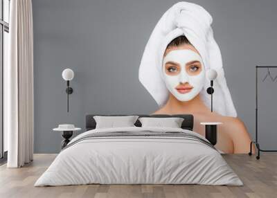 woman with towel on head and clay mask on face isolated on grey Wall mural