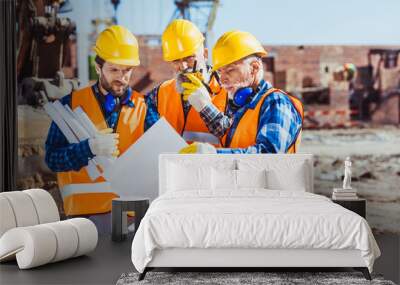 Workers examining building plans Wall mural