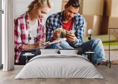 young couple counting money Wall mural