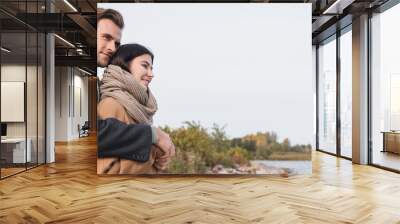 young couple in autumn outfit embracing while walking near lake, banner Wall mural