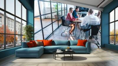 young disabled businessman in wheelchair working with smiling colleagues in office Wall mural