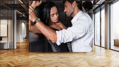 young elegant man hugging neck of seductive brunette woman in elevator Wall mural