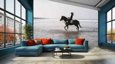 young female equestrian riding horse in water Wall mural