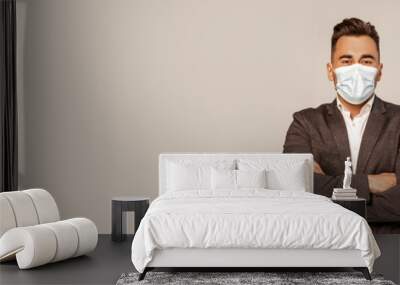 young man in medical mask standing with crossed arms isolated on grey with lilac shade, banner Wall mural