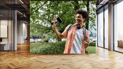 Young man taking selfie in park. Wall mural