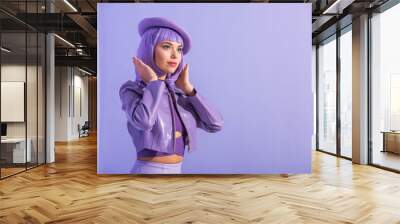 young woman dressed in doll style in beret posing on violet colorful background Wall mural