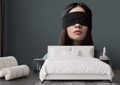 young woman wearing black blindfold isolated on grey Wall mural