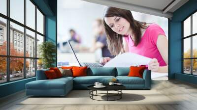 in the library - pretty female student with laptop and books wor Wall mural