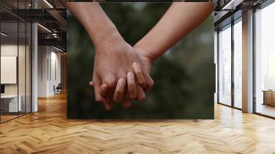 Lovers couple holding hands in a forest (summer/spring) Wall mural