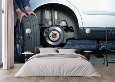 mechanic changing a wheel of a modern car (color toned image) Wall mural