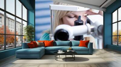 optometry concept - pretty young female patient having her eyes Wall mural