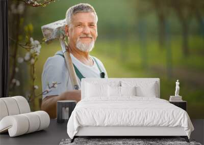 Portrait of a handsome senior man gardening in his garden Wall mural