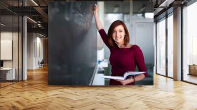 Pretty, young college student writing on the chalkboard, blackboard during a math class Wall mural