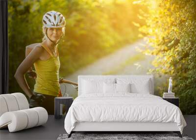 Pretty, young woman biking on a mountain bike enjoying healthy active lifestyle outdoors in summer (shallow DOF) Wall mural