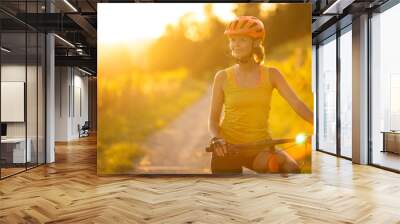 Pretty, young woman biking on a mountain bike enjoying healthy active lifestyle outdoors in summer (shallow DOF) Wall mural