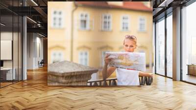 Pretty young female tourist studying a map,  Wall mural