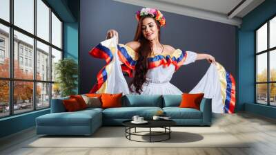 Colombian lady smiling and dancing against gray background. Isolated Wall mural