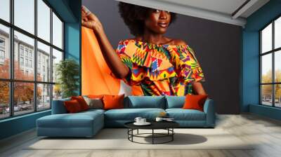 Happy african woman in national clothes smiling and posing with a flag Ivory Coast, C te d'Ivoire isolated over a gray background Wall mural