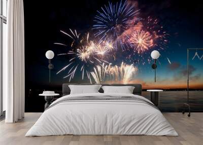 Holiday fireworks above water with reflection on the black sky background Wall mural