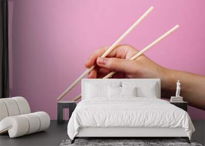 Instruction: how to hold chopsticks eat with chopsticks. Isolated on pink background. step 4 Wall mural