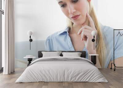 concentrated chic businesswoman reading newspaper sitting on cou Wall mural