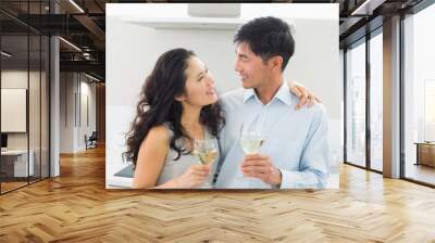 Loving young couple with wine glasses in kitchen Wall mural