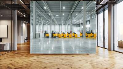 a lot of trucks standing in a row in a big, empty warehouse. the parade of trucks. new technology for a warehouse. Wall mural