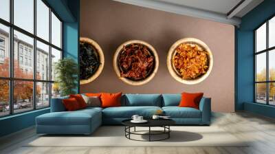 Three hookah bowls with aromatic tobacco on a brown table with smoking accessories. Hookah smoking in a hookah lounge. Red, yellow, black hookah tobacco Wall mural