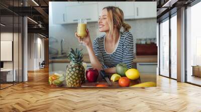 Happy smiling  healthy woman drinking smoothie Wall mural