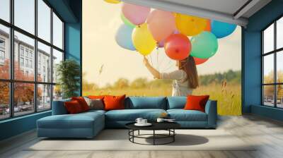 happy woman holding colorful balloons in a field - embrace joy with this image of a happy woman hold Wall mural