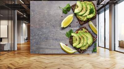 Delicious wholewheat toast with guacamole and avocado slices. Wall mural