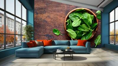 Fresh organic spinach leaves in a wooden bowl . Top view with copy space. Wall mural