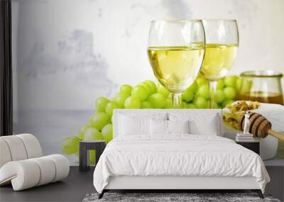 Two glasses of white wine,cheese and grapes. Wall mural