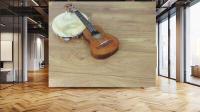 Close-up of two Brazilian musical instruments: cavaquinho and pandeiro (tambourine) on a wooden surface. They are widely used to accompany samba and choro, two popular Brazilian rhythms. Top view. Wall mural