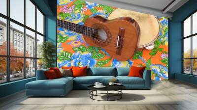 Two Brazilian musical instruments: cavaquinho and pandeiro (tambourine) on a very colorful “chitao” fabric with large floral prints. They are widely used to accompany samba and choro music. Wall mural