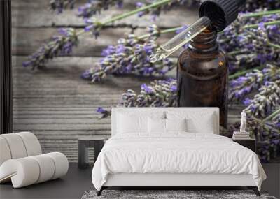 Herbal oil essence and dreied lavender flowers on wooden backgro Wall mural