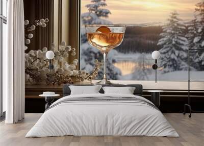 a beautifully crafted cocktail in a glass placed on a rustic windowsill. The soft glow of indoor lighting contrasts with the serene winter landscape outside the window. Wall mural